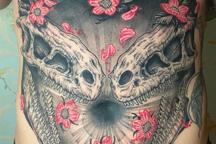 Tattoo of dinosaur skulls and flowers