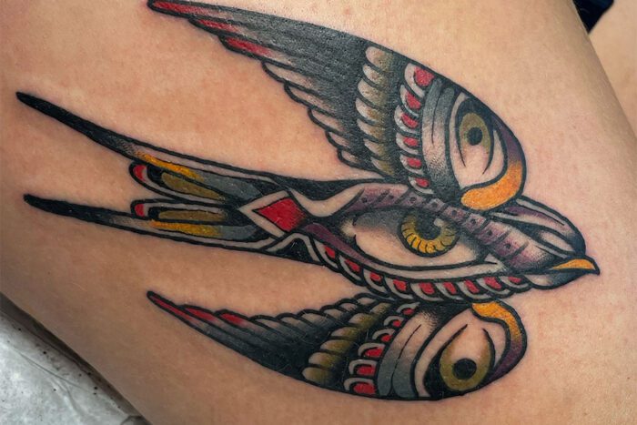 Bird with eye on belly tattoo