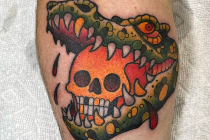 Skull in crocodile mouth tattoo