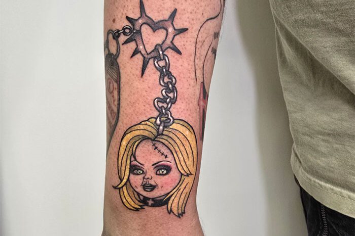 Severed doll head on keychain, tattoo by Brianne Hixx