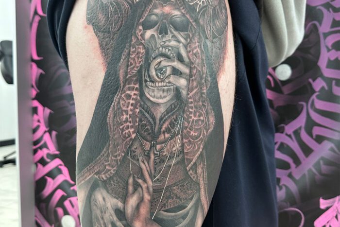 Tattoo of skull with eyeball in mouth