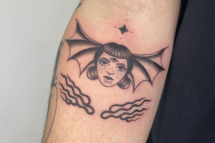 Woman head with bat wings, tattoo by Sam McGuffin
